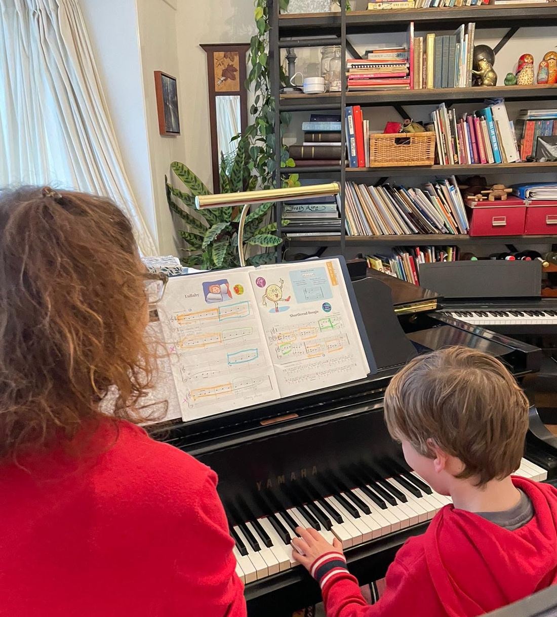 Lori Evans teaching a young piano student at the piano in her Haarlem-Noord home studio
